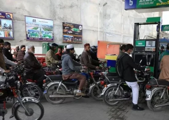 People wait for their turn to get fuel at a petrol station in Peshawar.