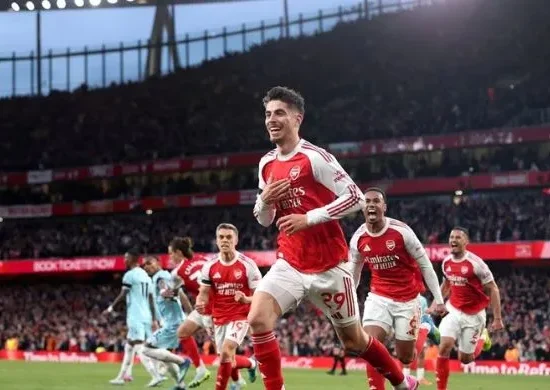 Arsenal players celebrating a goal at Emirates Stadium during the 2025/26 Premier League season, highlighting Max Dowman and teammates after clinching the title.