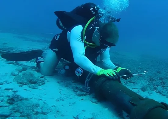 Technician diver repairs an underwater internet cable on the ocean floor, representing the submarine cable maintenance linked to Pakistan’s expected week-long internet slowdown.