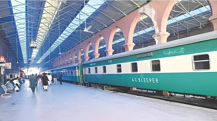 Pakistan Railways passenger train standing at a railway station platform, representing the government’s reported plan to outsource 15 passenger train operations to private operators.