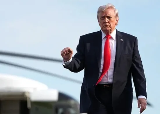 US President Donald Trump walks near a military aircraft, reflecting the decision to pause the Strait of Hormuz operation amid diplomatic efforts involving Pakistan and Iran.