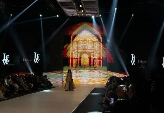 LAAM Fashion Week Season 2 Day 2 runway show in Lahore featuring a model in traditional attire against an illuminated architectural backdrop celebrating Pakistani fashion and heritage.