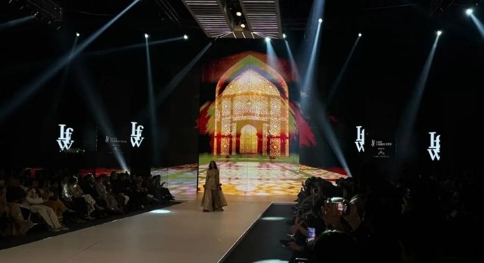 LAAM Fashion Week Season 2 Day 2 runway show in Lahore featuring a model in traditional attire against an illuminated architectural backdrop celebrating Pakistani fashion and heritage.